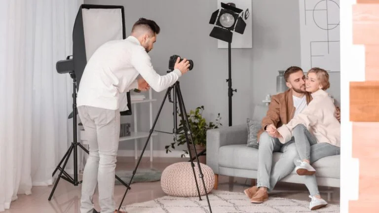 Sessão de fotos em ambiente interno com casal de homem e mulher sentados no sofá.