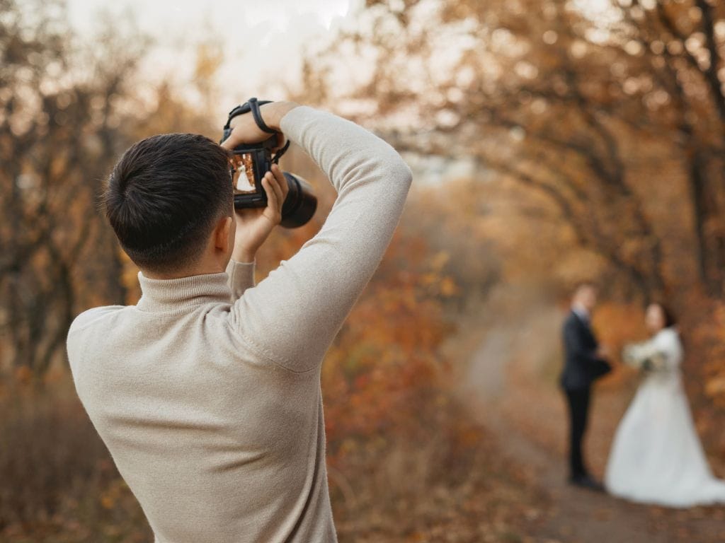 fotógrafo tirando fotos dos noivos em ambiente externo