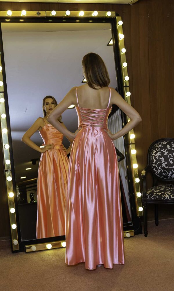 Costas do vestido de festa dois em um em cetim na cor rosa, esse modelo pode ser usado longo ou curto.