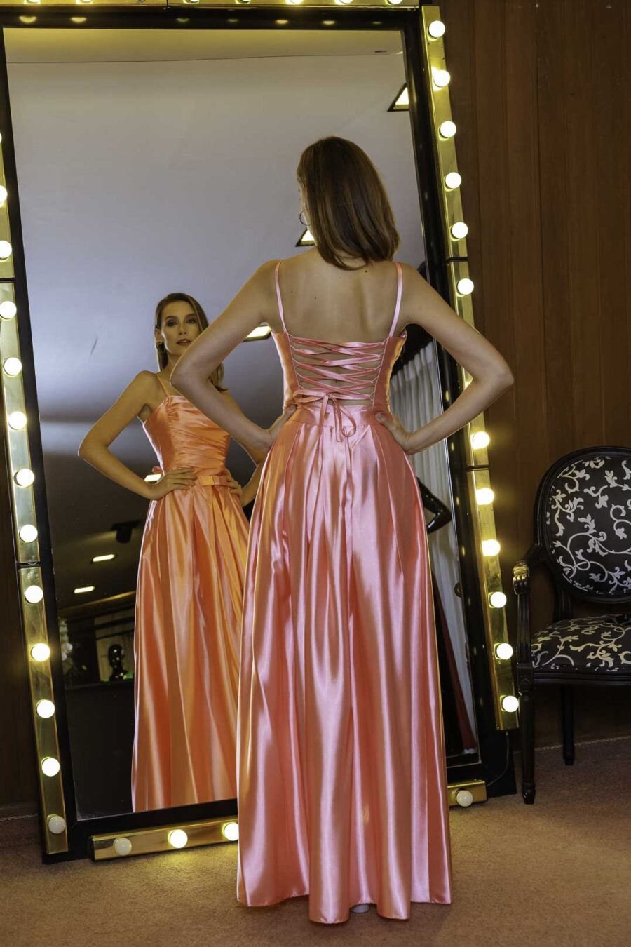 Costas do vestido de festa dois em um em cetim na cor rosa, esse modelo pode ser usado longo ou curto.